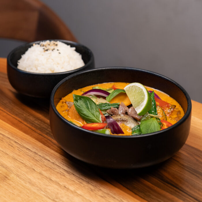 Rotes Thai Curry in einem schwarzen Teller im Restaurant Mishio in Bern