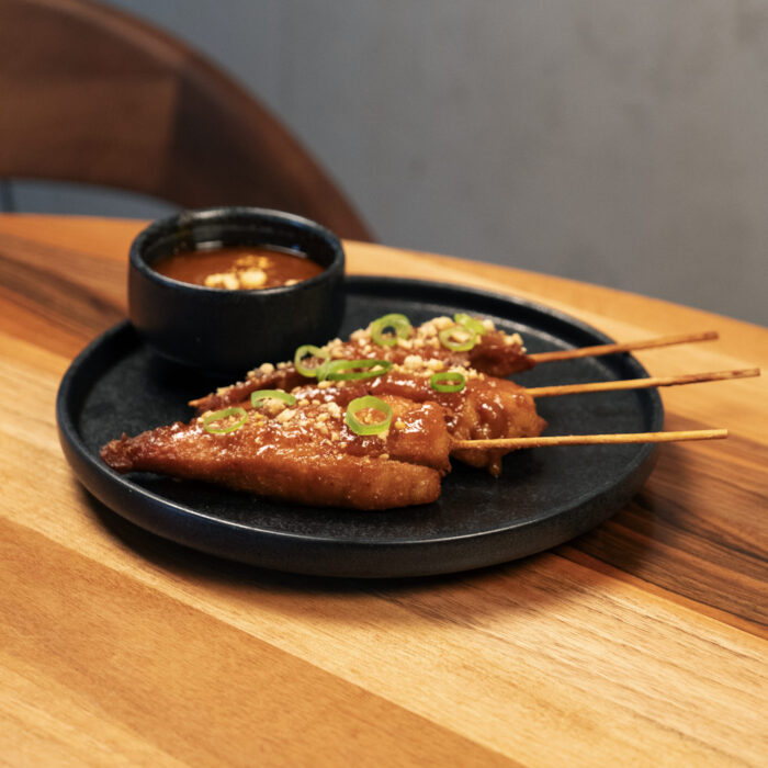 Satay-Spiesse auf einem schwarzen Teller im Restaurant Mishio in Bern