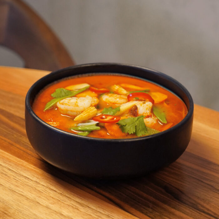 Tom Yam Suppe in einem schwarzen Teller im Restaurant Mishio in Bern