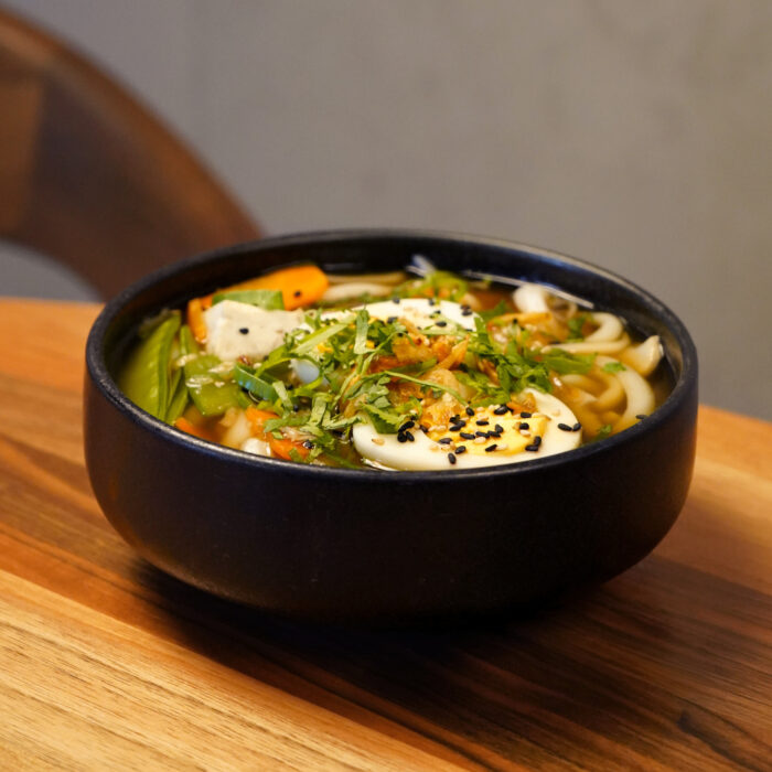 Udon Nudelsuppe in einem schwarzen Teller im Restaurant Mishio in Bern